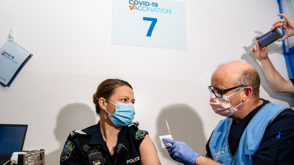 A police officer receives the Pfizer vaccine at a clinic in Adelaide
