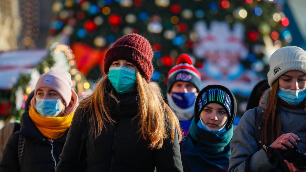 Russian people wearing a protective face masks walk on a street decorated for the upcoming Christmas and New Year"s celebrations during the pandemic of SARS-CoV-2 coronavirus Moscow, Russia, 28 December 2020