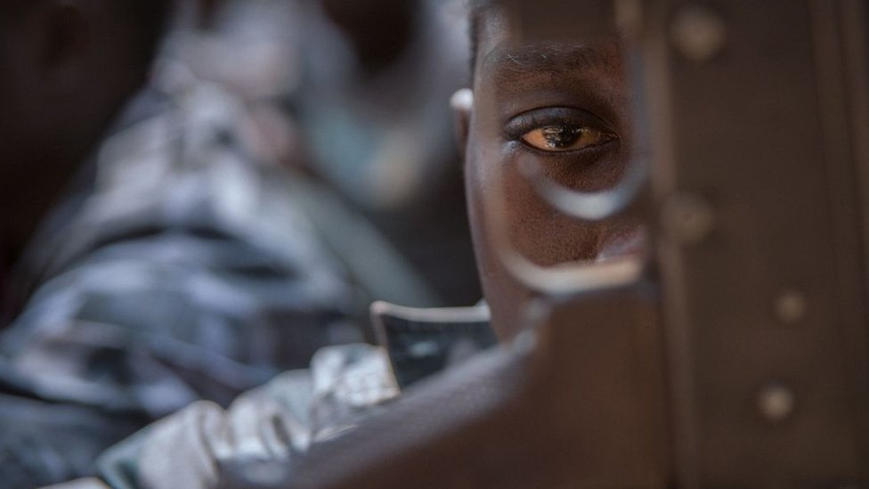 Un niño soldado recién liberado mira a través de un rifle durante una ceremonia de liberación de niños soldados en Yambio, Sudán del Sur, el 7 de febrero de 2018.