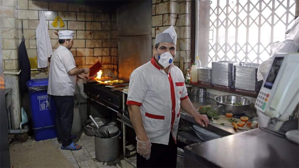 Повар носит маску в ресторане в Тегеране, Иран