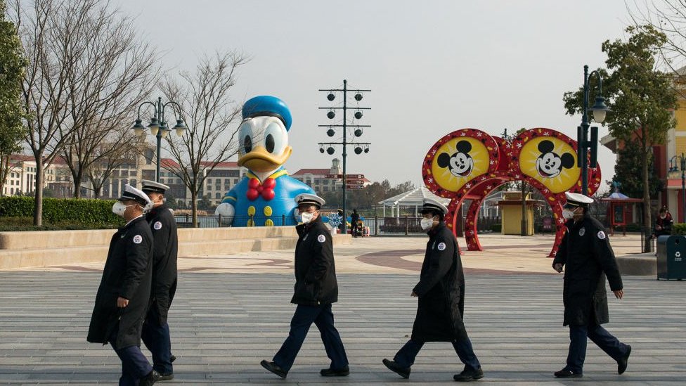 Сотрудники в защитных масках в Шанхайском Диснейленде.