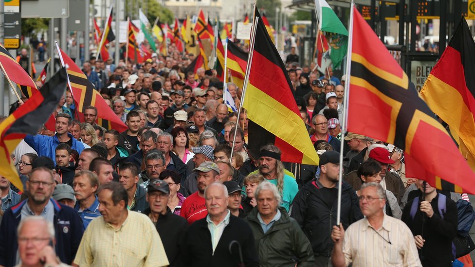 Supporters of the Pegida movement march through Dresden with German flags on 27 July, 2015.