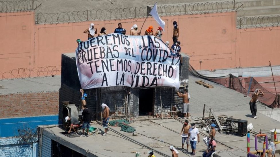 Заключенные в тюрьме Луриганчо держат плакат с надписью: «Мы хотим пройти тесты на Covid-19, мы имеем право на жизнь»