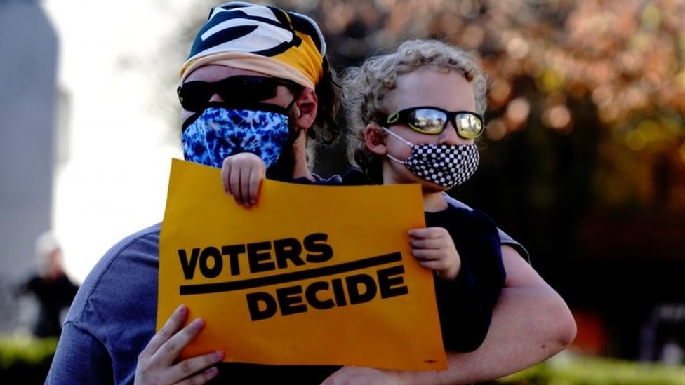 A Biden supporter counter-protests at a pro-Trump "stop the steal" rally in Wisconsin