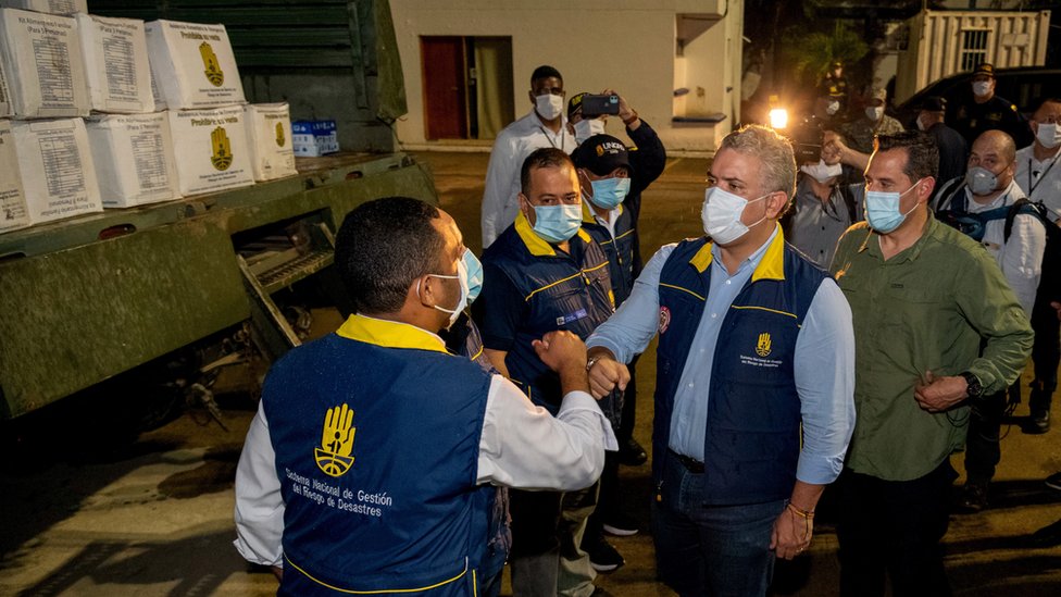 El presidente de Colombia, Iván Duque, saluda a los trabajadores del reparto de ayuda