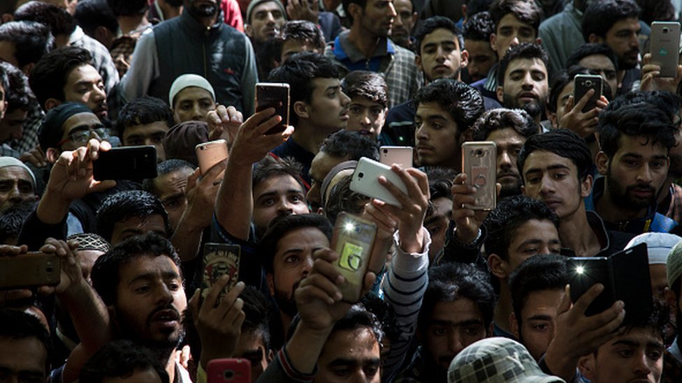 Жители Кашмирской деревни щелкают фотографии на своих мобильных телефонах во время похорон подростка Адила Магрея в Шопиане, примерно в 60 километрах (38 милях) к югу от Сринагара, Кашмир под управлением Индии, среда, 7 июня 2017 г.