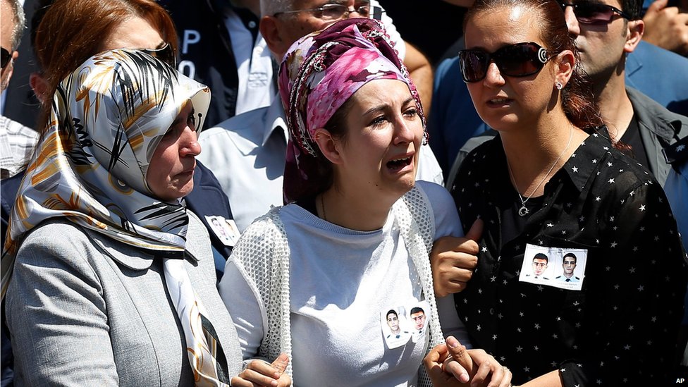 Родственники полицейских Фейяз Юмусак и Окан Ачар скорбят во время их похоронной процессии в Шанлыурфе, на юго-востоке Турции, четверг, 23 июля 2015 г.