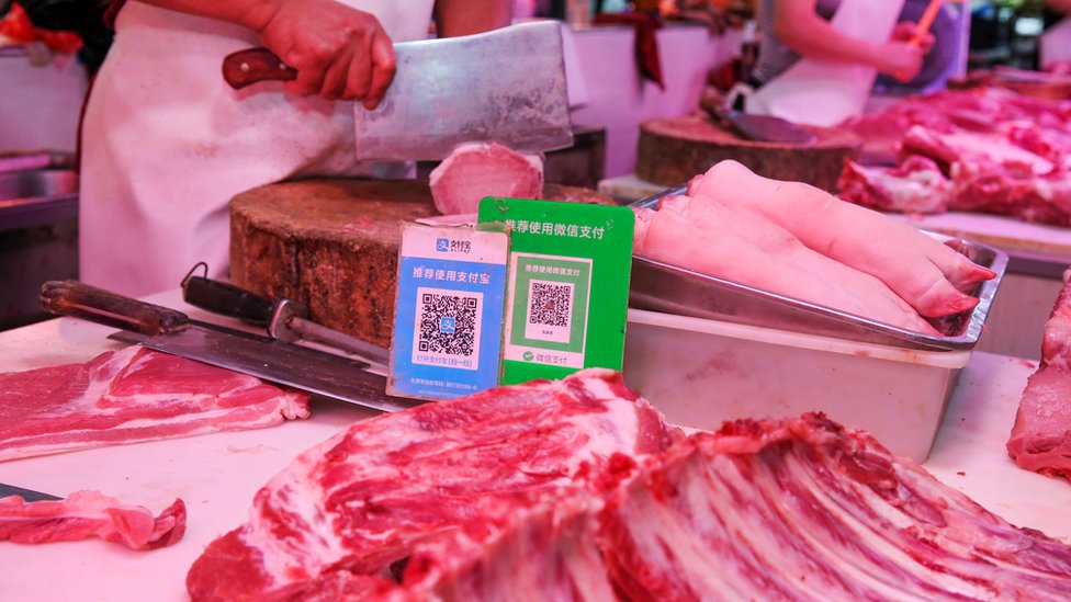 QR-коды Alipay и Wechat для онлайн-платежей отображаются на мясной лавке на рынке в Наньтуне в восточной провинции Китая Цзянсу 10 сентября 2018 г.