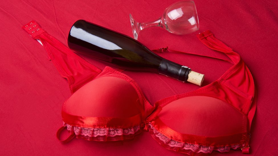 Sostén rojo y botella de champán