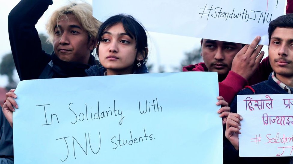 Студенты из Университета Джавахарлала Неру (JNU) держат плакаты, выражая свою солидарность после нападения там