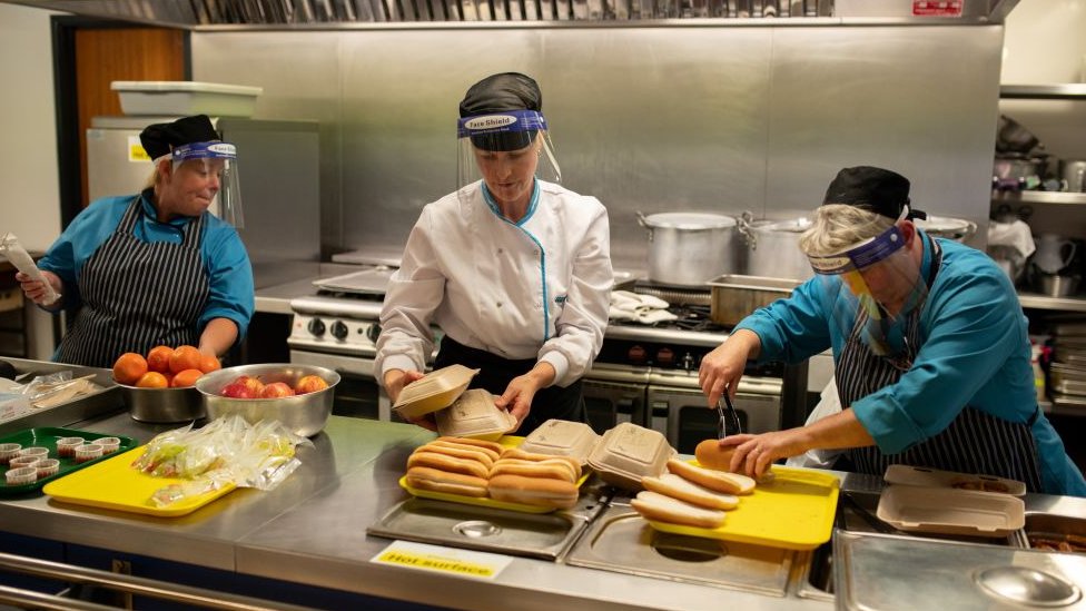 Kitchen staff prepare school lunches for pupils