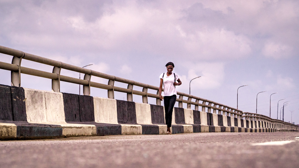 Женщина идет по Третьему материковому мосту в Лагосе, Нигерия