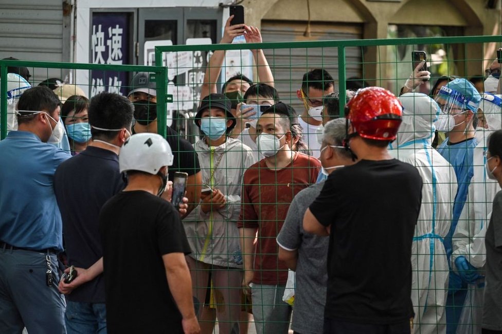 2022年6月6日，憤怒的居民在上海徐匯區一個街區的圍牆後面與官員對峙。