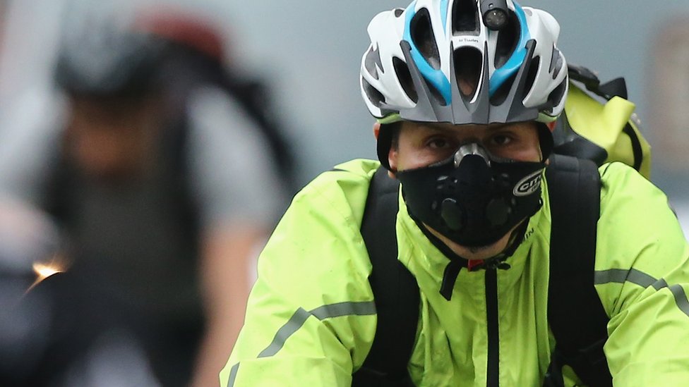 Велосипедист в дыхательной маске в центре Лондона