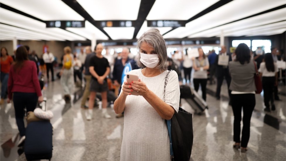 Mujer con mascarilla en el aeropuerto argentino de Ezeiza
