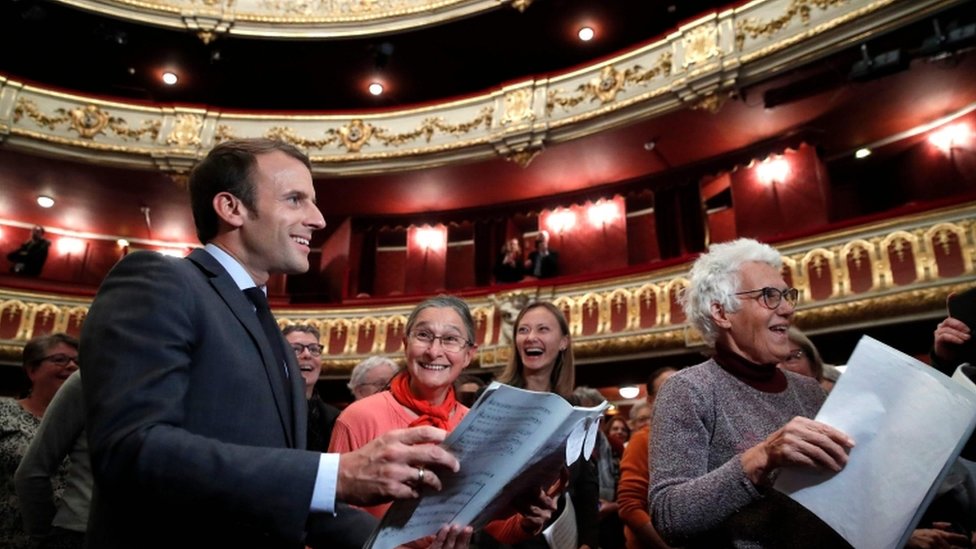 Президент Макрон улыбается, когда присоединяется к группе женщин во время репетиции в Опере