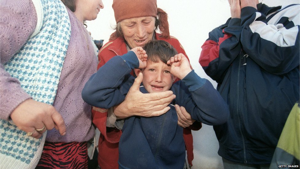 На снимке, сделанном 7 марта 1998 года, изображена пожилая женщина-беженка из числа этнических албанцев из деревни Донье Преказе, которая плачет, держа внука, скрываясь от сербской полиции в доме в лесу недалеко от их деревни