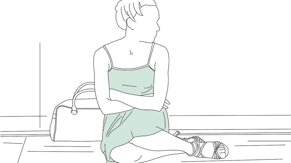 Mujer sentada en el suelo.