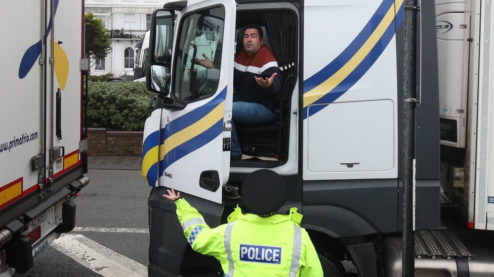 A police officer talks to an exasperated lorry driver outside the Port of Dover in Kent on Monday