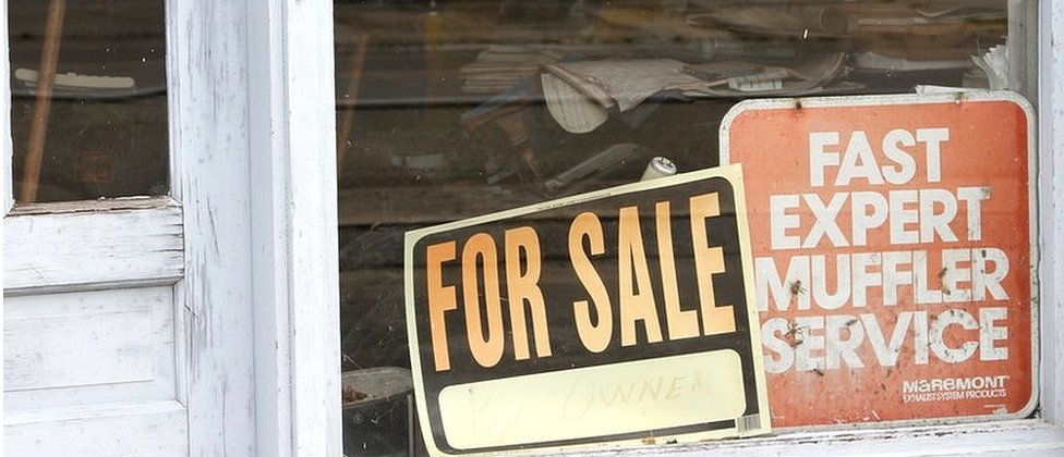 Negocios vacíos y carteles de venta, "For sale", son una postal frecuente en el centro de Jamestown. Cartel de "En venta" en una vidriera