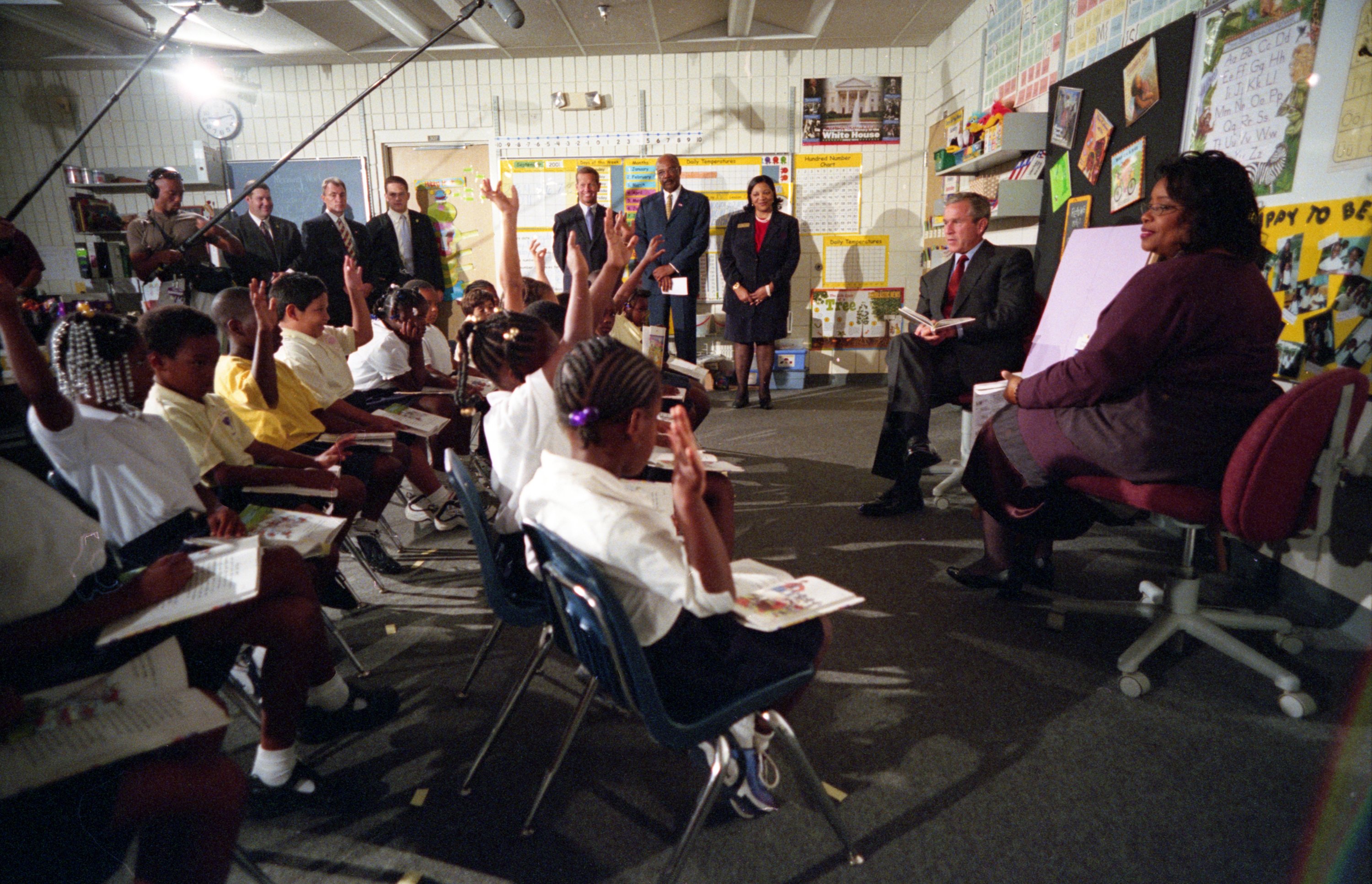 Класс Букеровской школы поднял руки вверх, а президент Буш сидит перед ними.