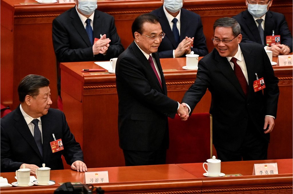 3月11，在北京舉行的中國全國人民代表大會第四次全體會議期間，在習近平的注視下，中國前總理李克強（中）與新當選的總理李強（右）握手。