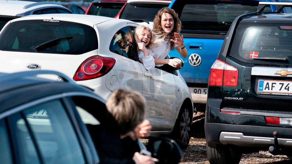 Daneses festejan la Pascua desde sus carros en un aparcamiento.