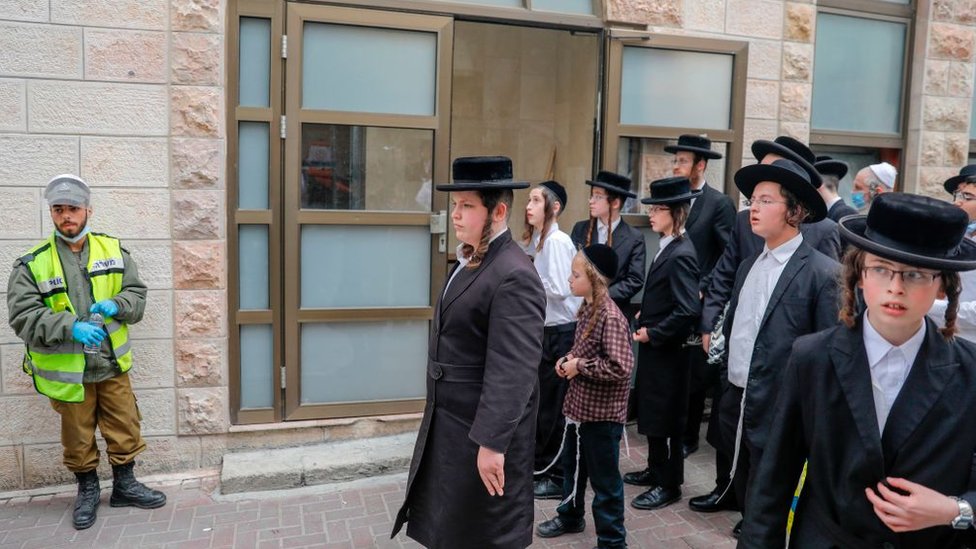 Ultraortodoxos tratan de entrar en una sinagoga después de que la policía ordenó que salieran.