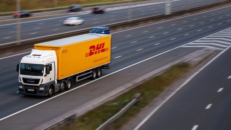 Грузовик DHL в движении по автомагистрали - стоковое фото