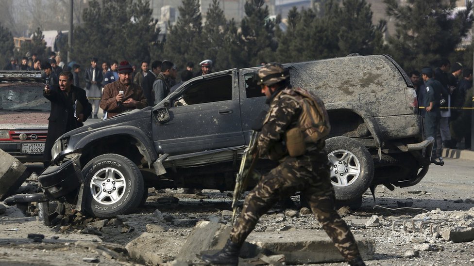 На этом снимке от 28 декабря 2016 года сотрудники службы безопасности Афганистана осматривают место взрыва бомбы на обочине дороги в Кабуле, Афганистан