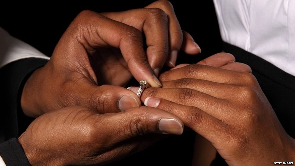 Мужчина надевает обручальное кольцо на палец женщины