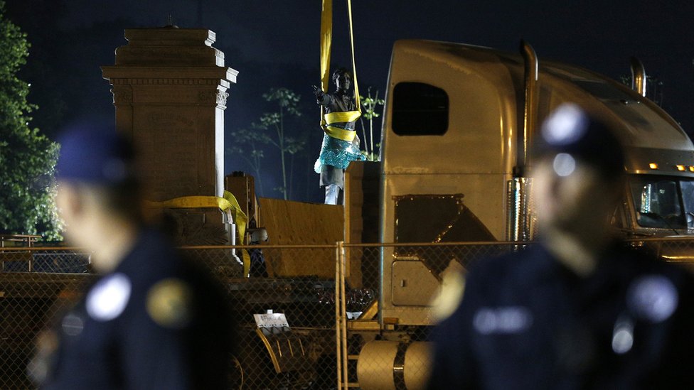 Durante la remoción del monumento a Jefferson Davis hubo fuerte presencia policial. Dos agentes de policía resguardan el lugar en el que se ubicaba la estatuab de Jefferson Davis.