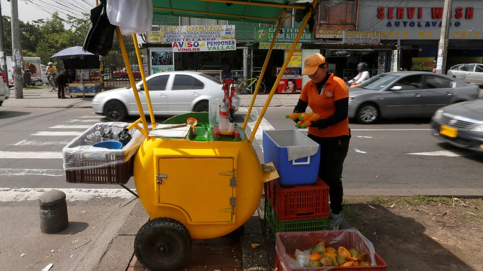 Mujer vendiendo jugo de frutas en Colombia