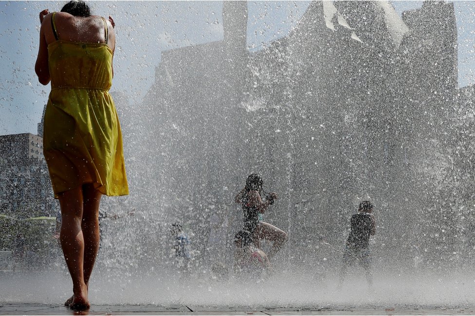 أطفال وكبار يستممتعون بماء النافورة المنعش في أول أيام موجة الحر الصيفية في بوسطن.