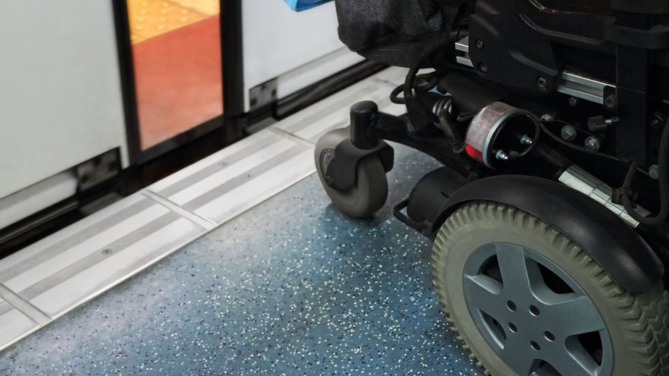 Инвалидная коляска на платформе перед поездом с частично открытыми дверями