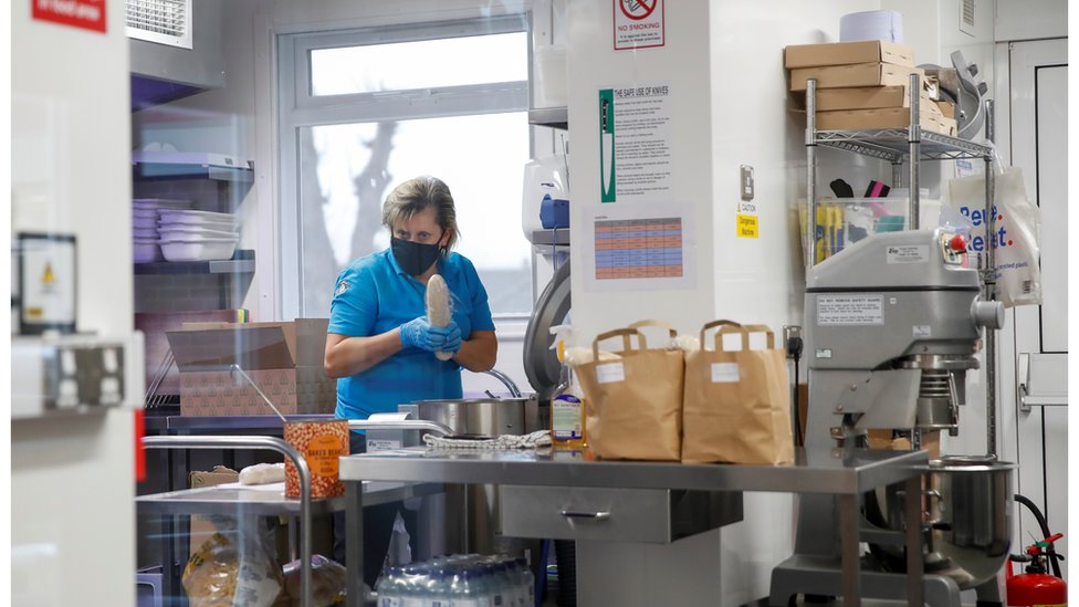 Woman in face mask preparing meals for children on free school dinners in lockdown, Milton Keynes