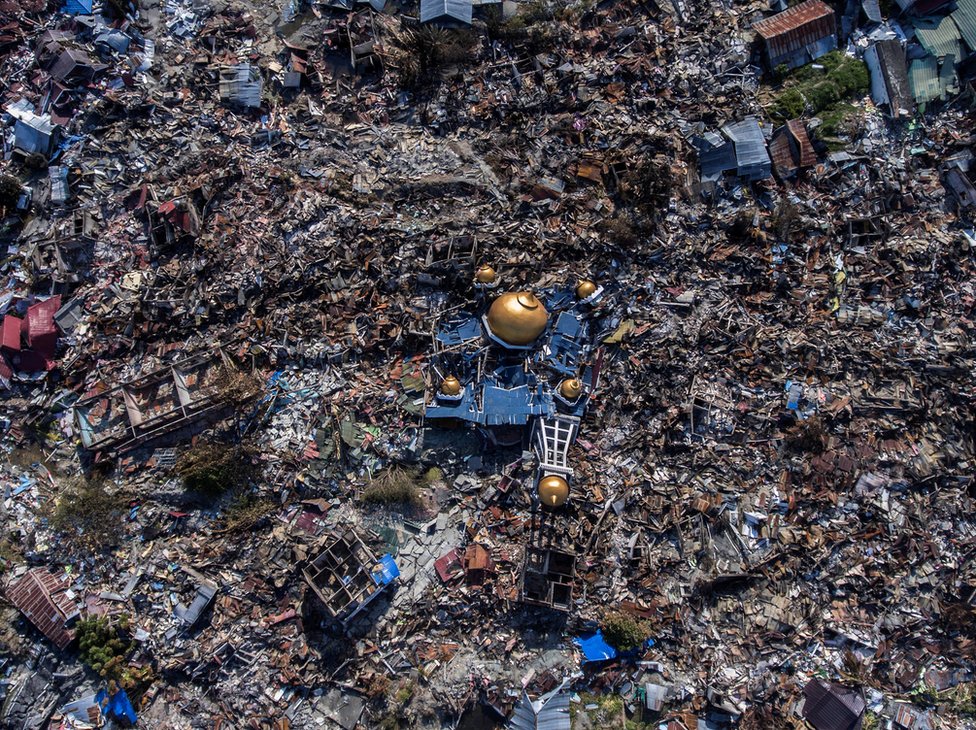 Aerial view of a collapsed mosque amid rubble in