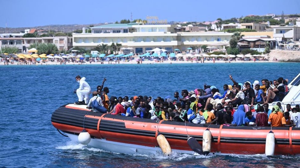 Some migrants are taken in dinghy to board the 'Galaxy' ferry which will head towards Porto Empedocle, Lampedusa, southern Italy, 15 September 2023