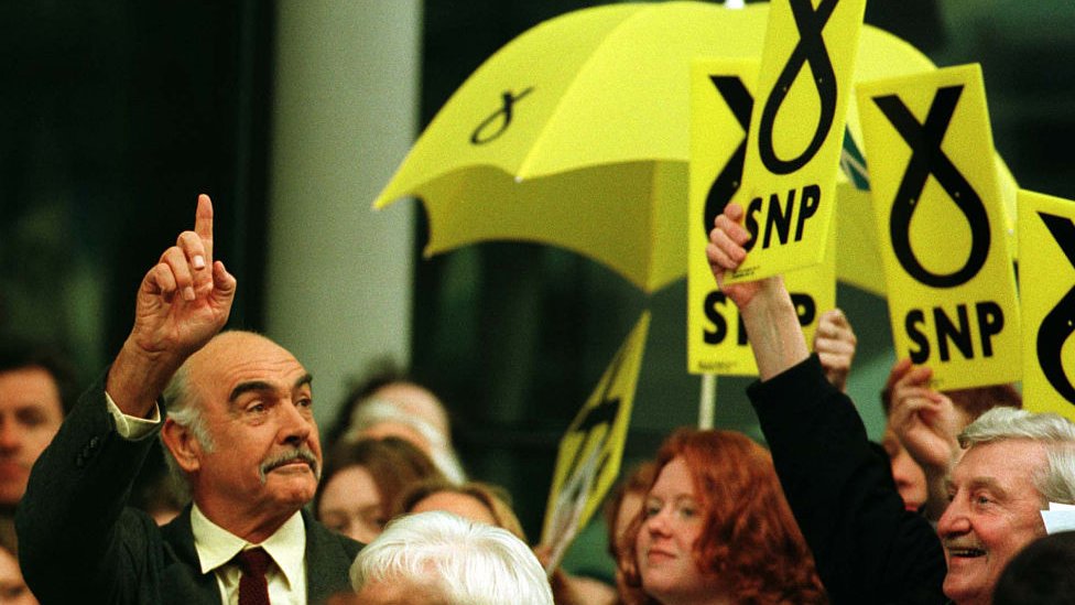 Толпа аплодирует Шону Коннери, когда он входит в конгресс SNP