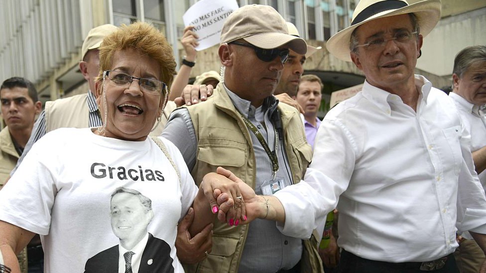 Uribe es uno de los dirigentes de oposición más populares en el país. Uribe toma de la mano a una de sus seguidoras, quien lleva una camiseta con el mensaje "Gracias" y la foto del expresidente.