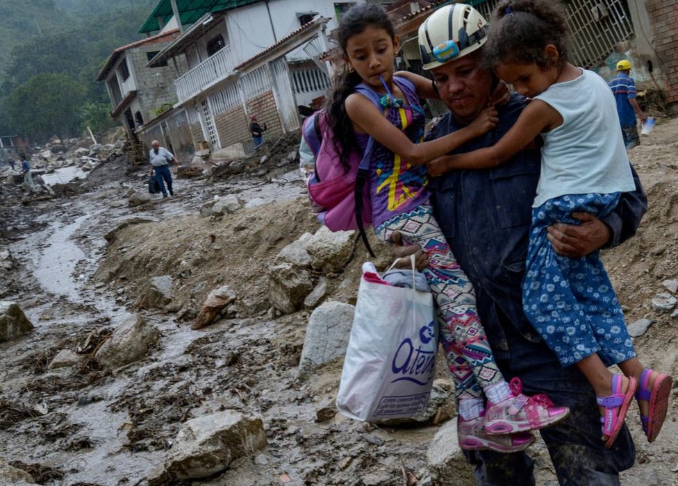 Rescatista con dos niñas en Tovar, Mérida, Venezuela.