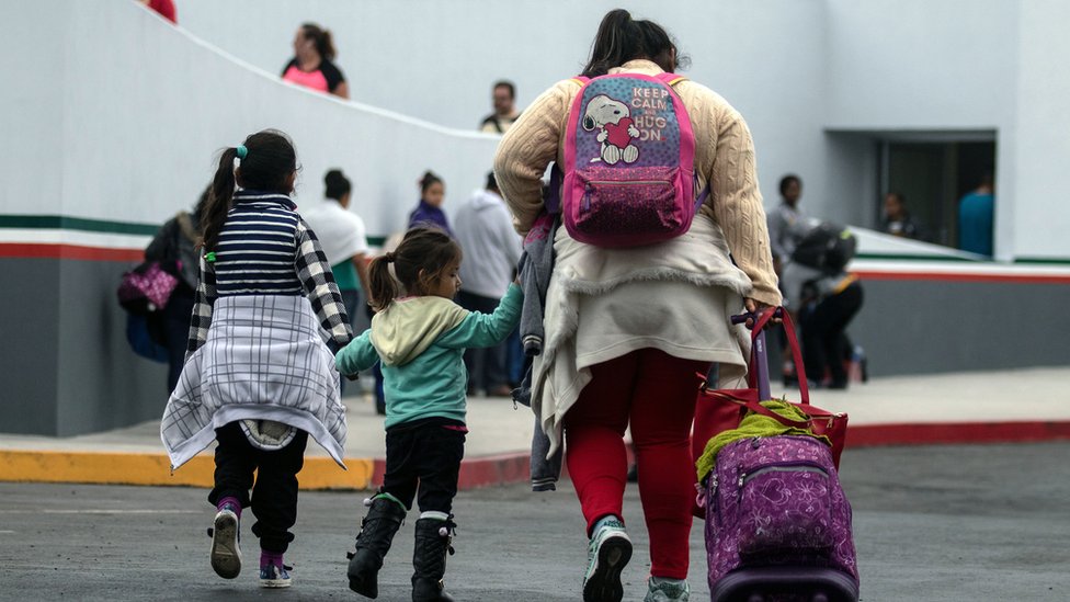 Inmigrantes caminando hacia el puerto de entrada de El Chaparral en Tijuana, México, en la frontera con Estados Unidos