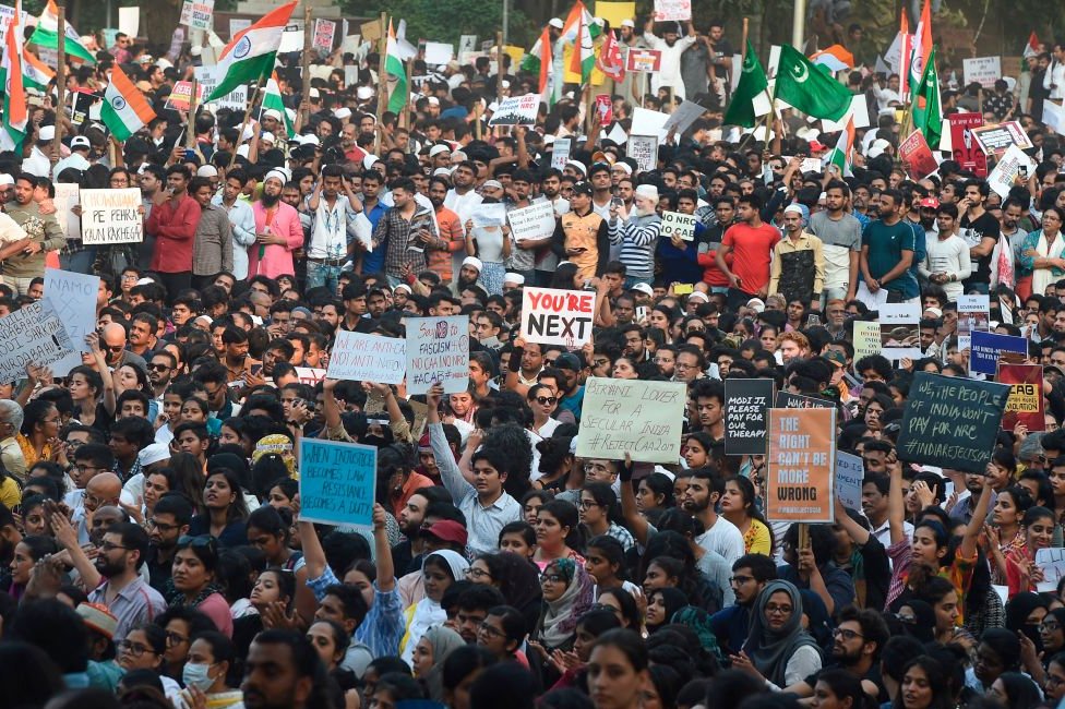 Протестующие держат плакаты во время демонстрации против нового закона Индии о гражданстве в Мумбаи 19 декабря 2019 г.