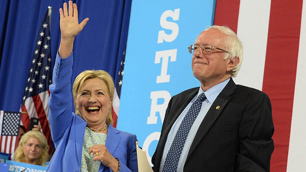 Хиллари Клинтон и Берни Сандерс выходят на сцену в Нью-Гэмпшире.