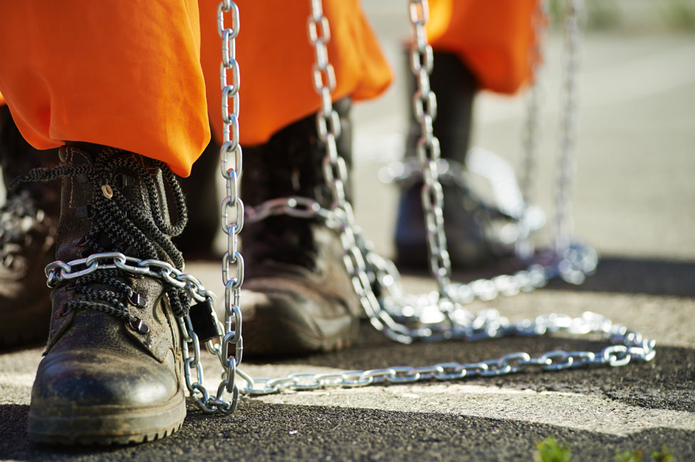 Prisioneros con cadenas en los pies.
