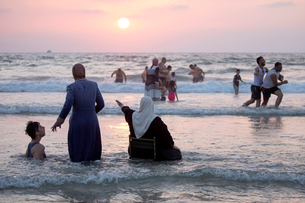 People enjoy themselves in the Mediterranean Sea during Eid al-Adha, in Tel Aviv, Israel