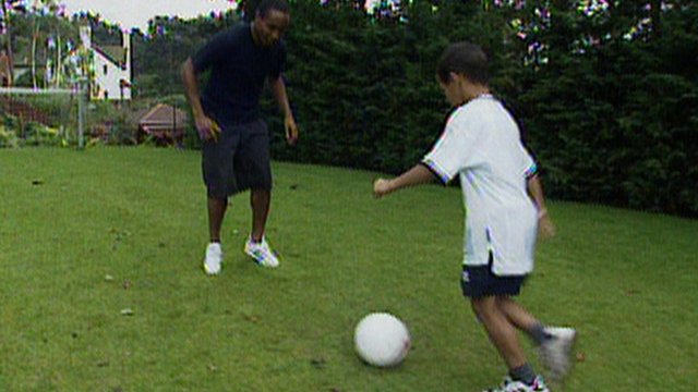 Paul Ince and Tom Ince play football in garden