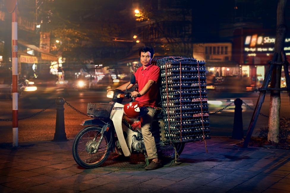 Мужчина позирует на мотоцикле с огромной грудой яиц на спине