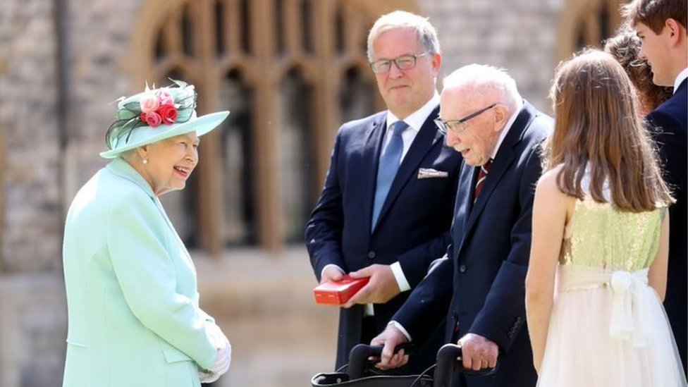 Queen Elizabeth II talks with the family of Captain Sir Thomas Moore after awarding him the insignia of Knight Bachelor at Windsor Castle on 17 July, 2020 in Windsor, England.