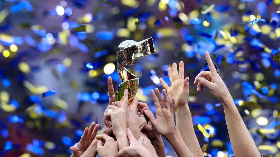 Hands belonging to the US team, reaching up to lift the Fifa Women's World Cup Trophy 2019